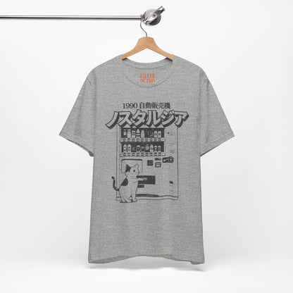 Gray t-shirt with a graphic design of a cat and vending machine on a hanger against a white background