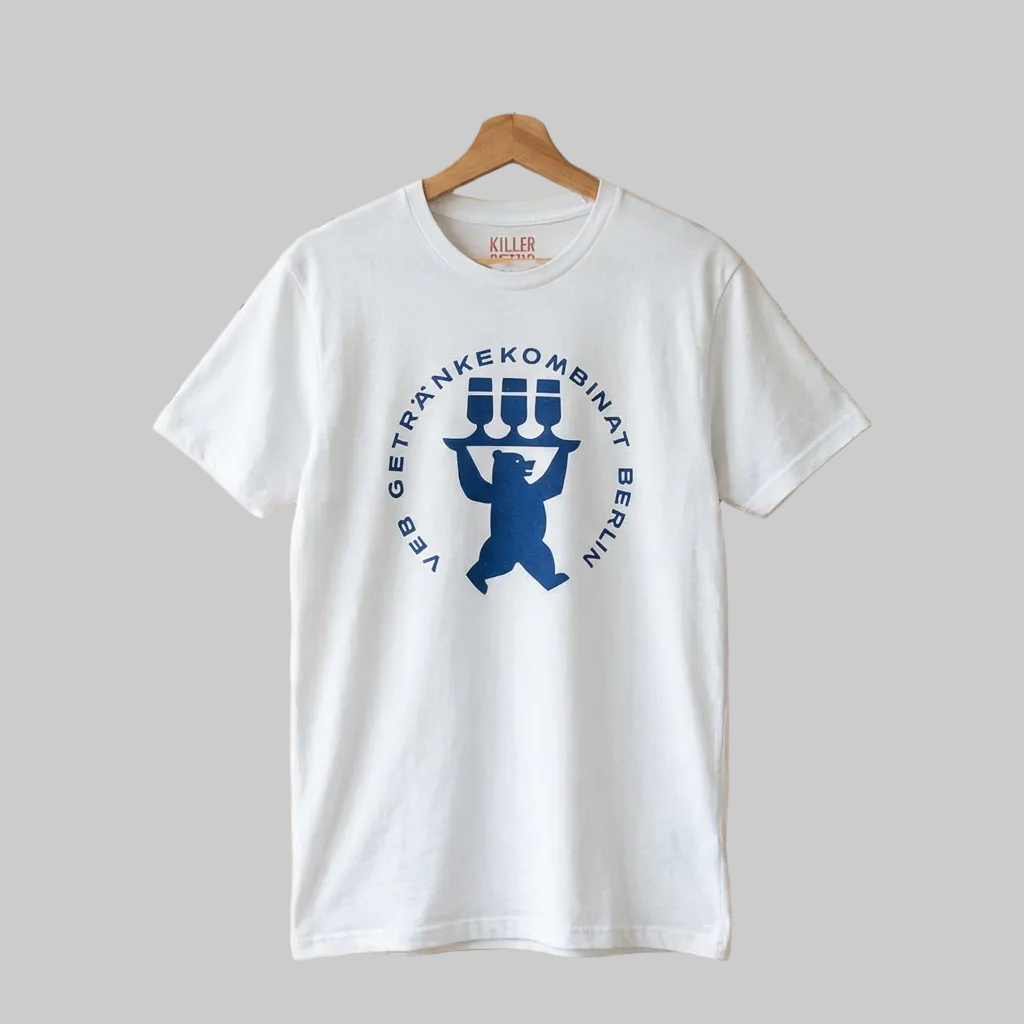 White t-shirt with blue graphic design on a wooden pegboard background