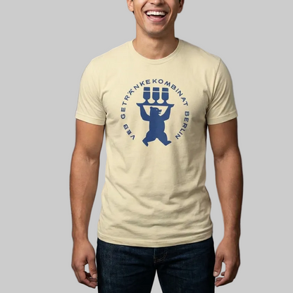 Man wearing a beige t-shirt with a blue graphic design on a gray background