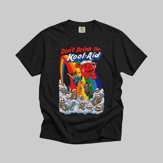 A black short-sleeve t-shirt laid flat on a textured gray concrete background, featuring a colorful retro graphic of the Kool-Aid brand with a red character, rainbow, skeletons, and the text 'Don't Drink The Kool-Aid'.