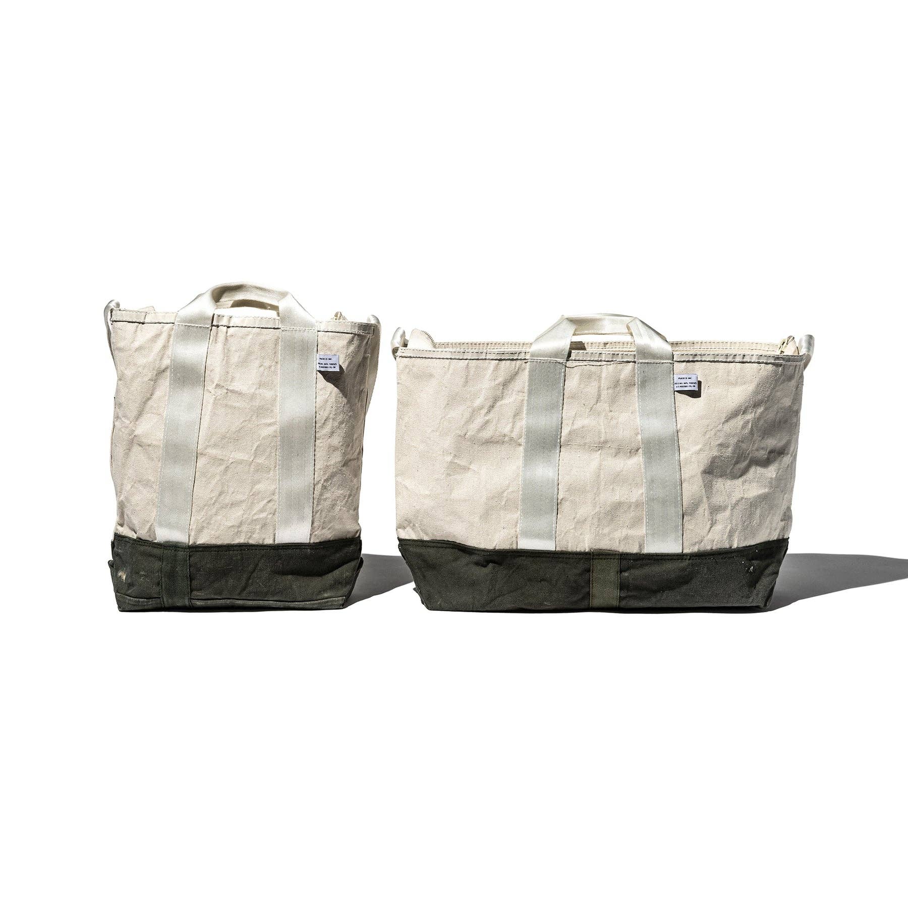 Two beige tote bags with black accents on a white background