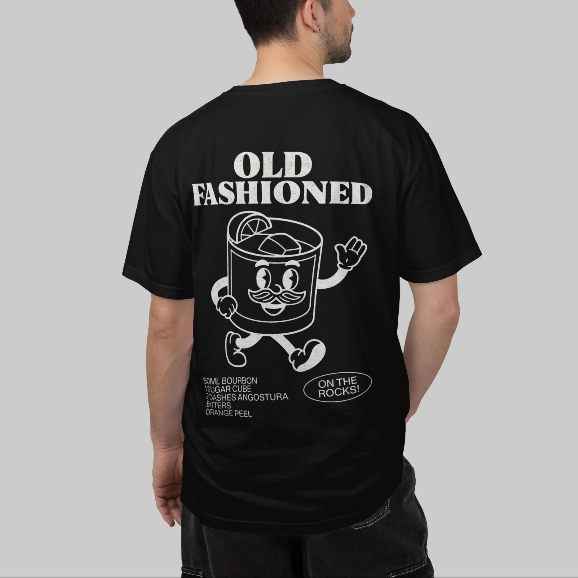 Man wearing a black t-shirt with 'Old Fashioned' graphic on the back, standing against a gray background