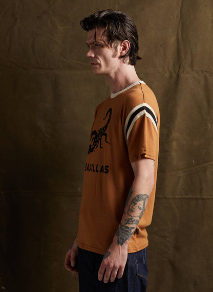 Man wearing a brown t-shirt with a graphic design against a textured brown background
