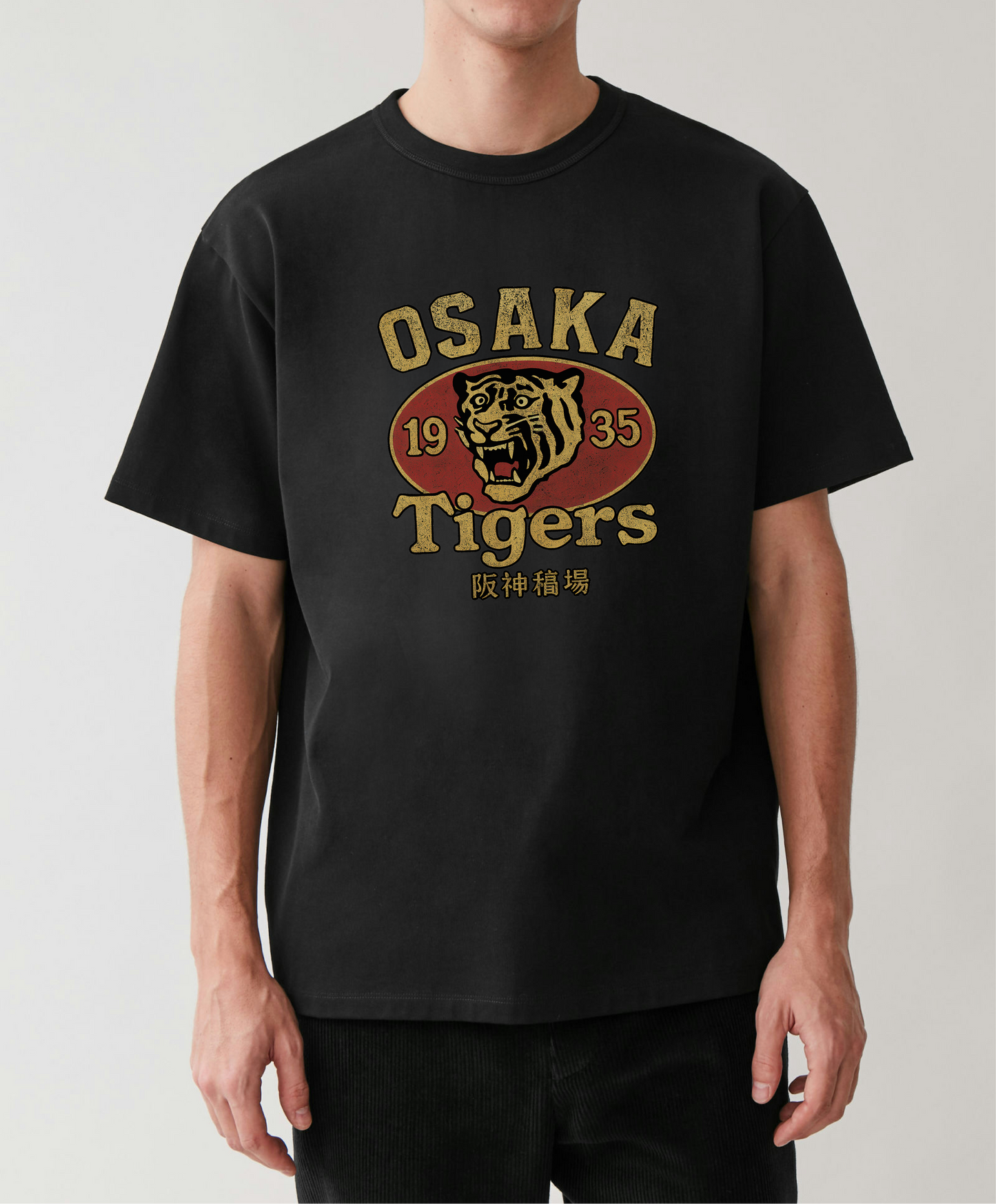 Person wearing a black t-shirt with 'Osaka Tigers' logo on a plain background