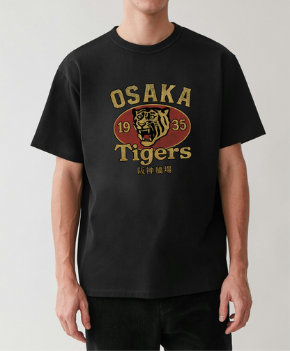 Person wearing a black t-shirt with 'Osaka Tigers' logo on a plain background