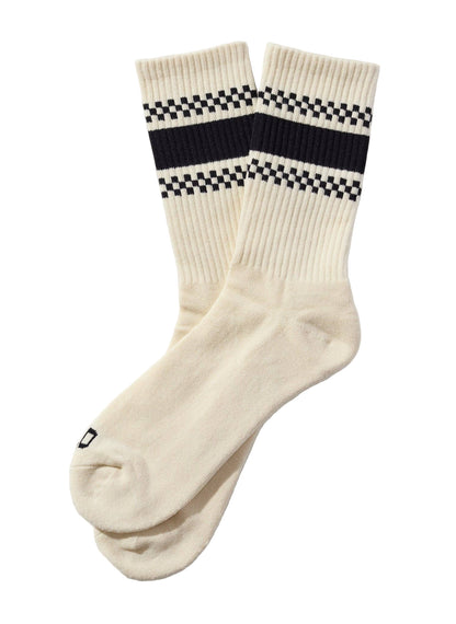 White socks with black and white checkered stripes on a beige background