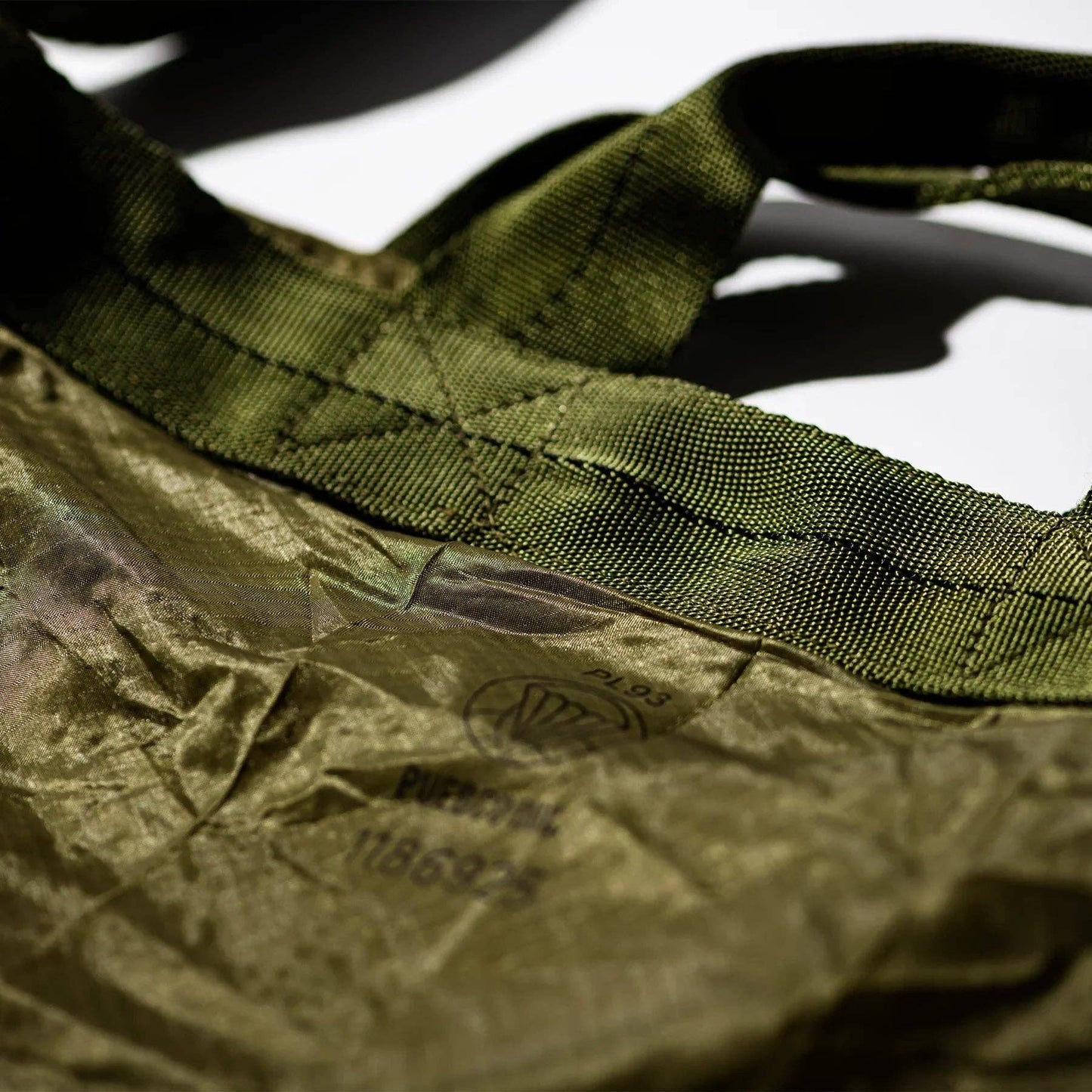 Close-up of a green fabric with a visible brand label on a white background